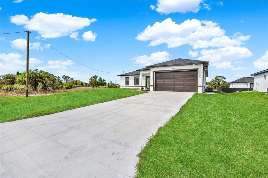 Front exterior of a new home in , Lehigh Acres, FL, highlighting curb appeal (Image 14).