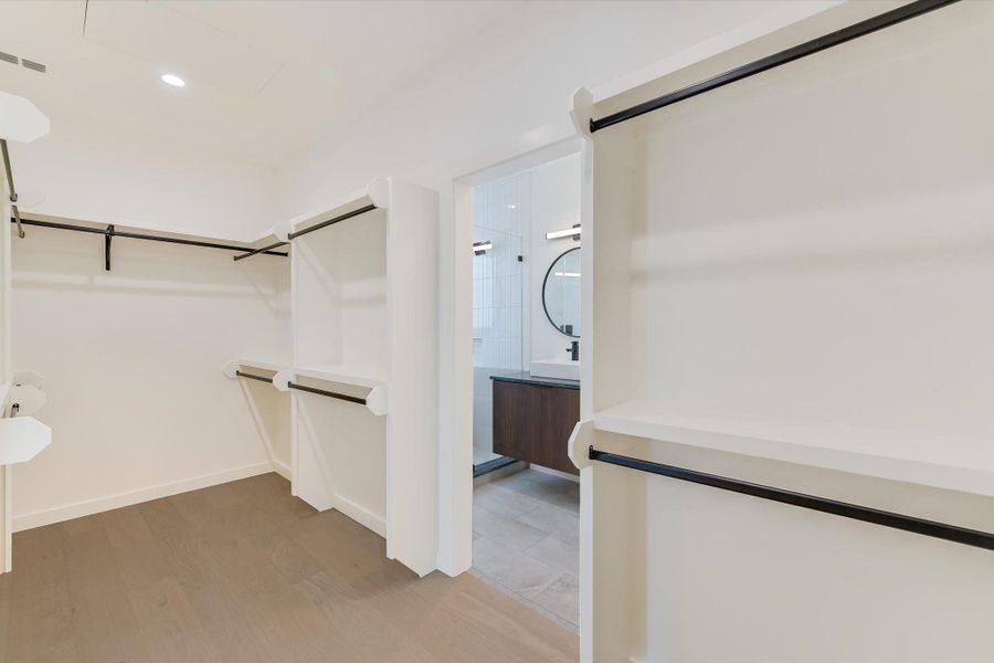 Spacious closet featuring light wood-style floors and a sink