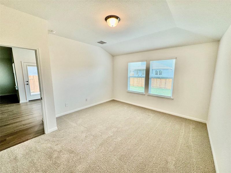 Empty room featuring carpet, lofted ceiling, and a textured ceiling Empty room featuring carpet, lofted ceiling, and a textured ceiling