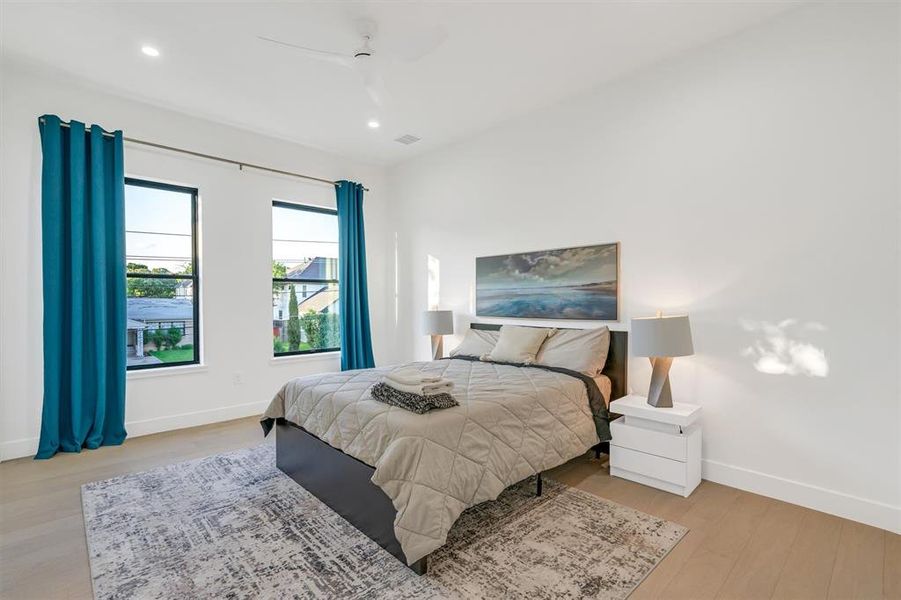Bedroom with light wood-type flooring, a ceiling fan, and recessed lighting
