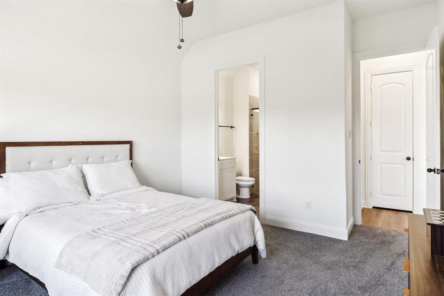 Carpeted bedroom with ensuite bath and baseboards Carpeted bedroom with ensuite bath and baseboards