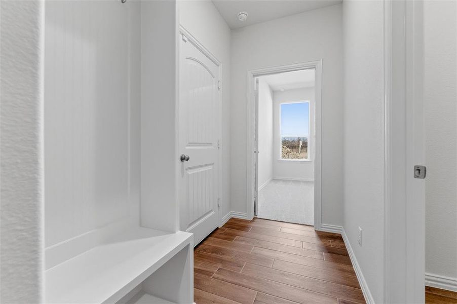 Mudroom with wood finished floors and baseboards