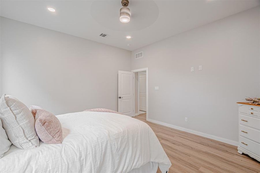 Room featuring light gray walls, recessed lighting, a modern ceiling fan, wood-finish flooring, and white trim