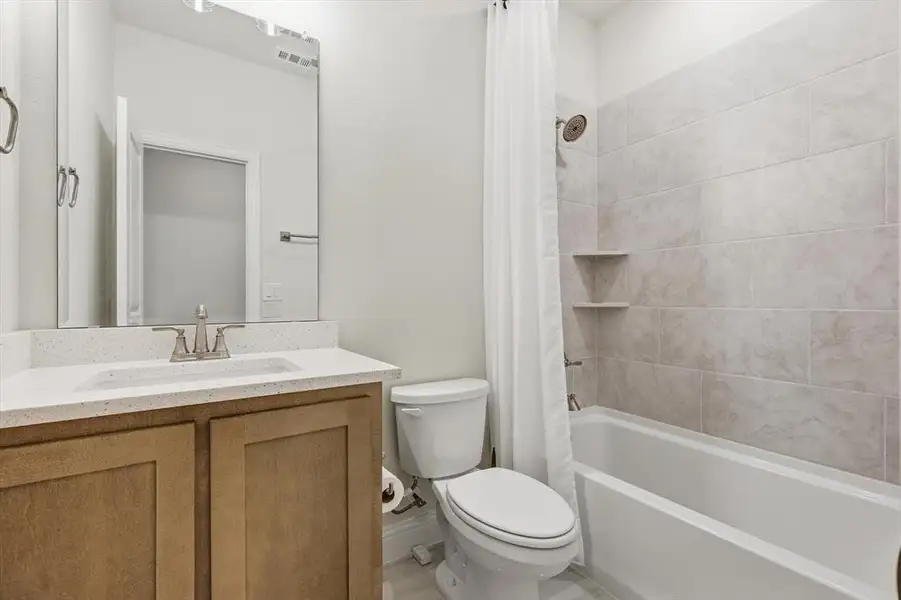 Bathroom featuring a light-toned vanity with a white countertop and undermount sink