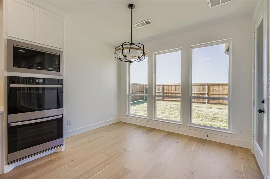 Unfurnished dining area with a chandelier and light wood-style flooring