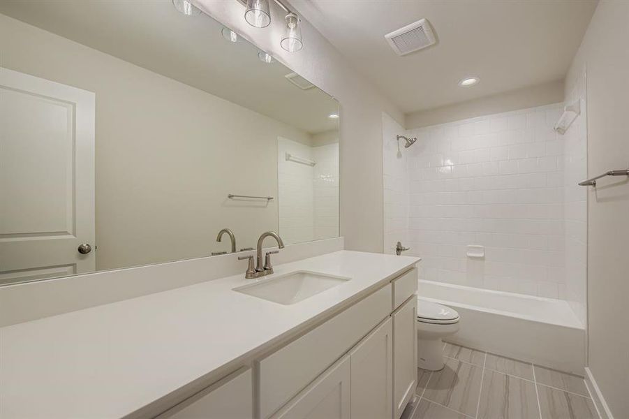 Bathroom with vanity, shower / bath combination, recessed lighting, and light tile patterned flooring Bathroom with vanity, shower / bath combination, recessed lighting, and light tile patterned flooring