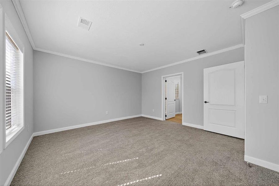 Unfurnished bedroom with ornamental molding and light carpet Unfurnished bedroom with ornamental molding and light carpet