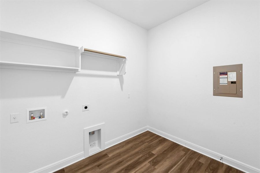 A dedicated laundry room with convenient shelving and hanging space.