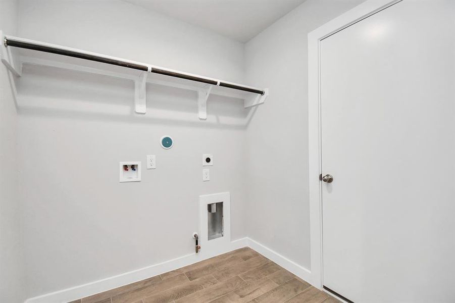 A perfect blend of functionality and comfort. Laundry room, thoughtfully equipped with shelving for effortless organization. Both gas and electric connections available. Sample photo of completed home with similar floor plan. Actual colors and selections may vary.