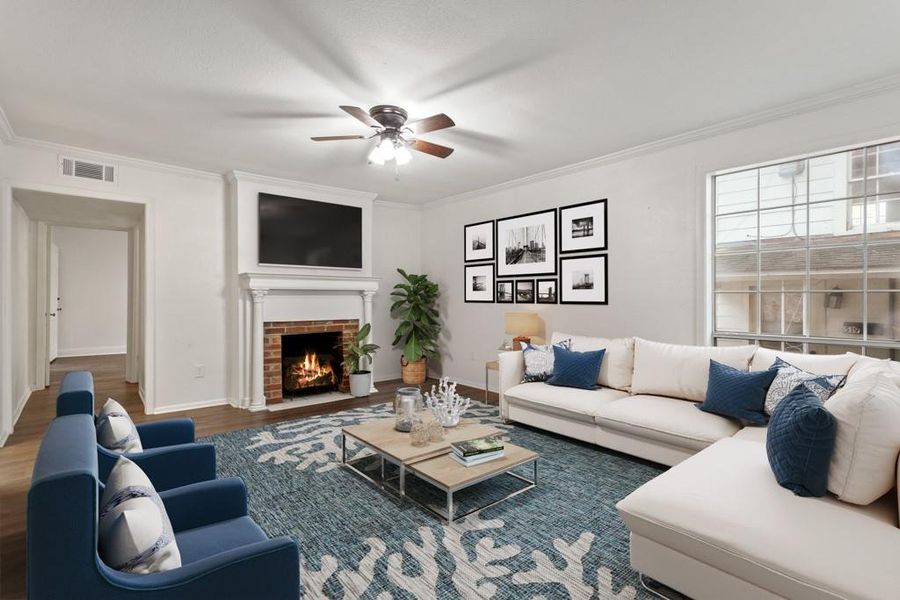 Living room with ceiling fan, crown molding, wood finished floors, a fireplace, and baseboards