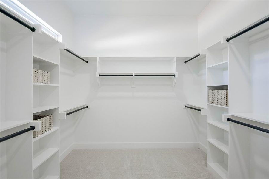 Walk in closet featuring light colored carpet Walk in closet featuring light colored carpet