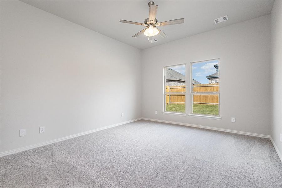 Carpeted empty room featuring ceiling fan