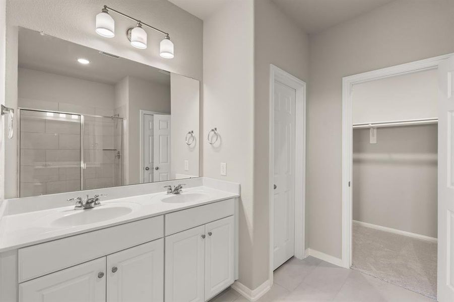 The en-suite bathroom offers a spa-like atmosphere with its elegant design, high end finishes, and tasteful lighting, creating a retreat within your own home.