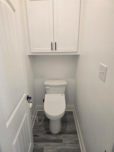 Bathroom with toilet and hardwood / wood-style flooring