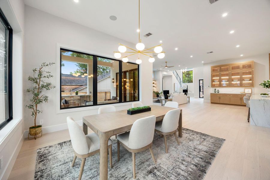 A beautifully balanced view of the dining and living areas, designed for seamless flow and connection. The open layout allows for effortless movement between spaces, while large windows enhance the natural light throughout. The highlight is the indoor-outdoor transition, offering a perfect blend of comfort and versatility for entertaining or everyday living.