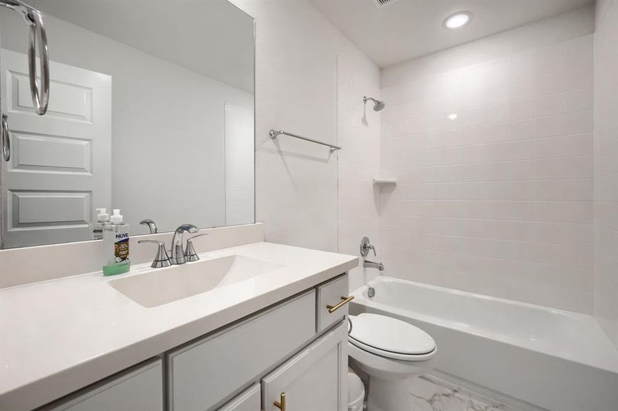 Full bathroom featuring vanity, toilet, and tiled shower / bath