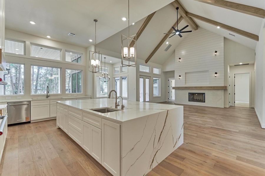 Seamless flow from the chef’s kitchen to the dining area, spacious living room, and cozy fireplace—enhanced by expansive windows and doors that open to the outdoor living space.