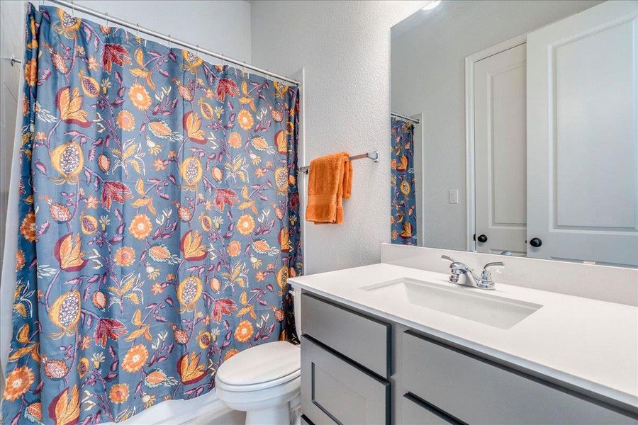 Full bathroom with a textured wall and vanity