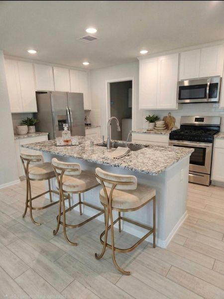 Kitchen fully equipped with appliances and island with sitting area and granite countertops Kitchen fully equipped with appliances and island with sitting area and granite countertops