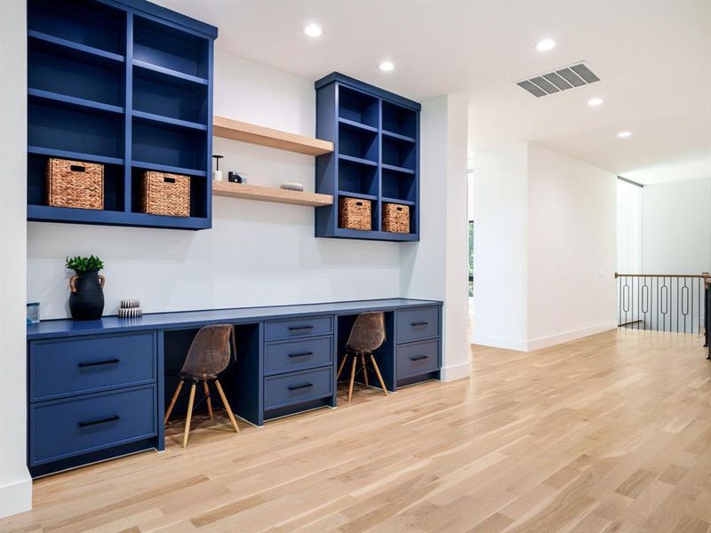 Office space with built in desk, light wood-style floors, and recessed lighting