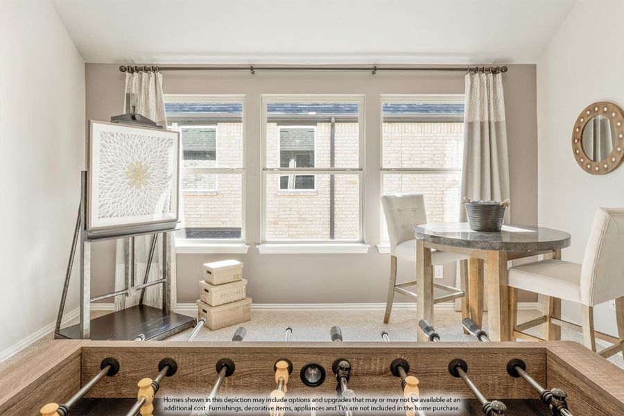 Game room with foosball table, small bistro table, and three windows with neutral curtains Game room with foosball table, small bistro table, and three windows with neutral curtains
