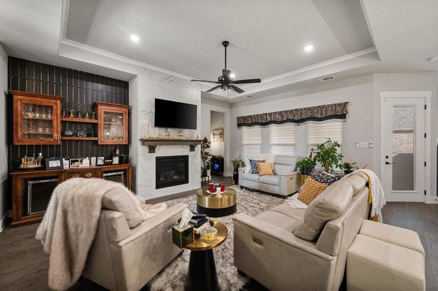 Marble front fireplace and customized cabinetry to the left of the fireplace is great for entertaining