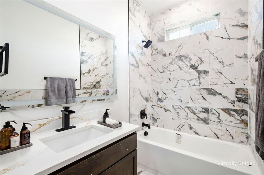 Bathroom featuring vanity and shower / bathtub combination