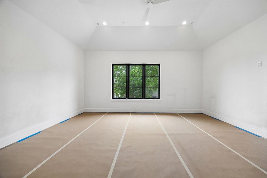 Primary Bedroom with vaulted ceilings and overlooking serene landscaping. Pictured April 2026.