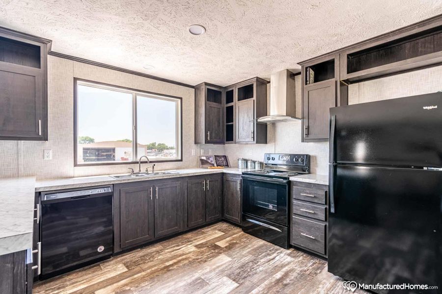 A well-appointed kitchen showcasing durable wood-look flooring and ample cabinet storage.