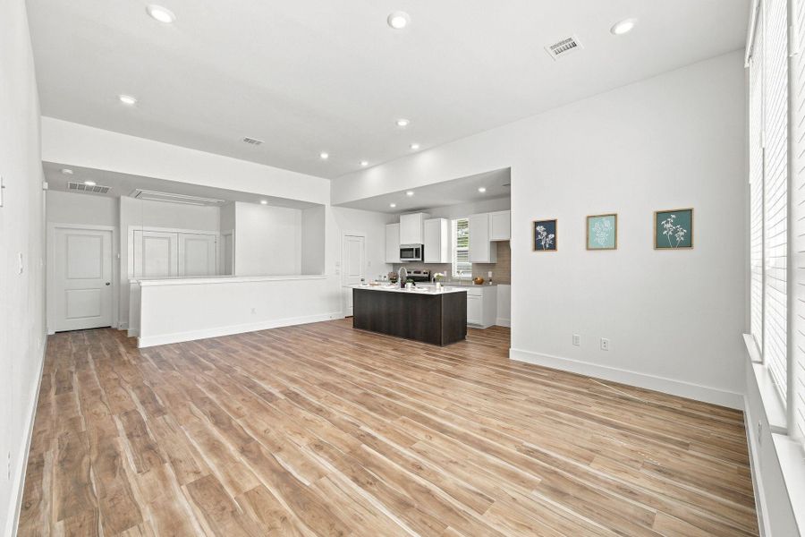 Spacious open-concept living and kitchen area with high ceilings, recessed lighting, and abundant natural light. Spacious open-concept living and kitchen area with high ceilings, recessed lighting, and abundant natural light.
