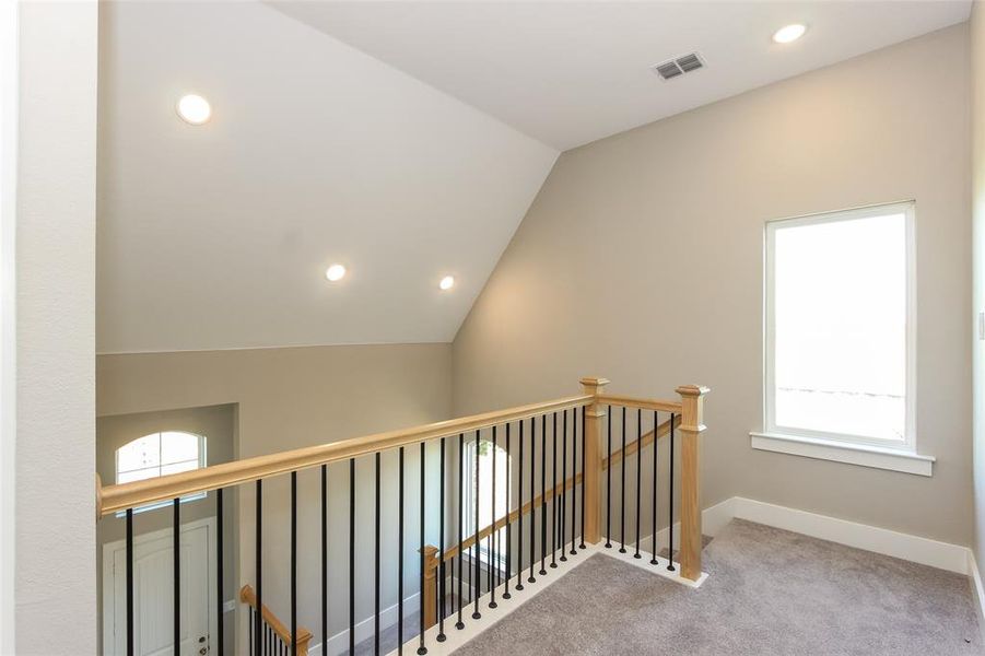 Hall with lofted ceiling and carpet flooring