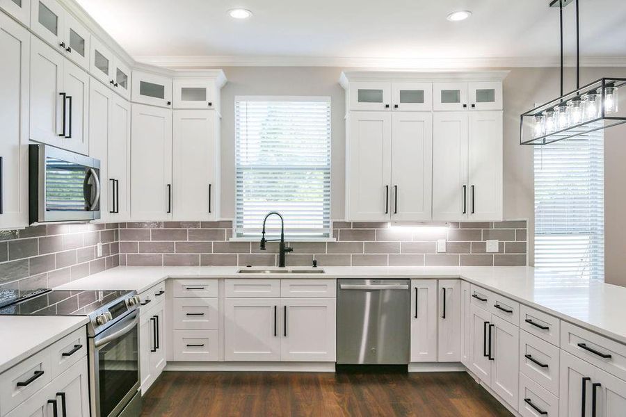 Kitchen with stainless steel appliances, healthy amount of natural light, white cabinetry, ornamental molding, and recessed lighting Kitchen with stainless steel appliances, healthy amount of natural light, white cabinetry, ornamental molding, and recessed lighting