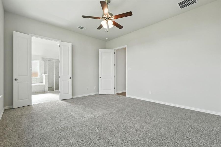 Unfurnished bedroom with carpet, ceiling fan, and ensuite bathroom