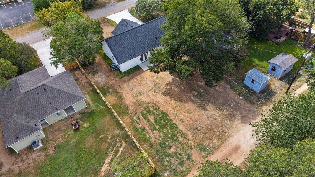An aerial perspective showcases the spacious lot with multiple structures and mature trees. An aerial perspective showcases the spacious lot with multiple structures and mature trees.