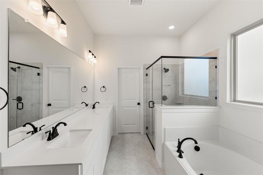 Full bathroom featuring double vanity, a garden tub, a stall shower, and recessed lighting
