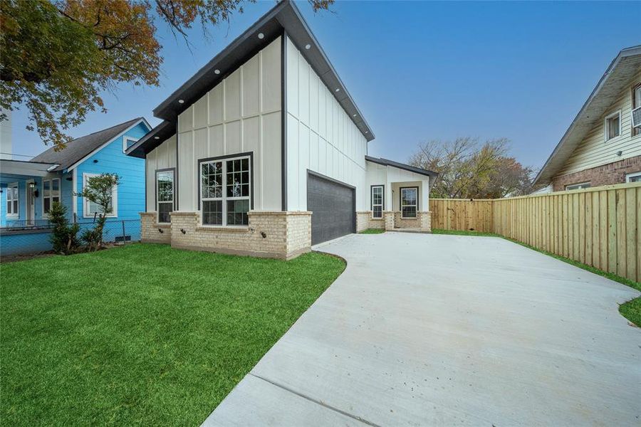 View of side of property featuring a yard and a garage