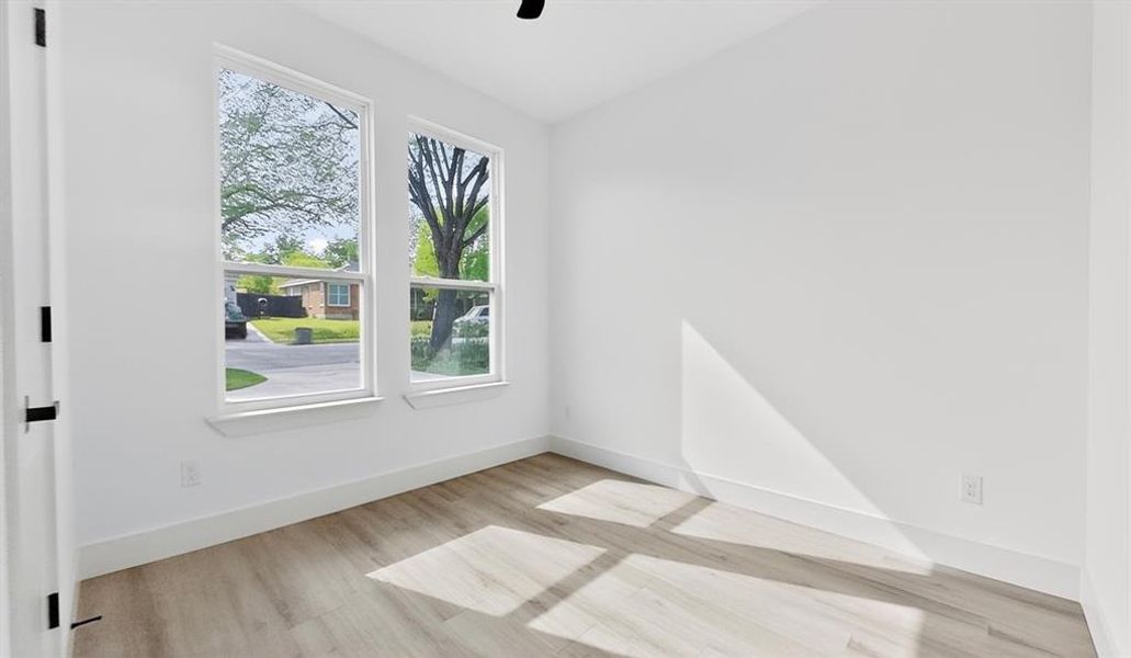 Spare room featuring light wood-type flooring, ceiling fan, and vaulted ceiling