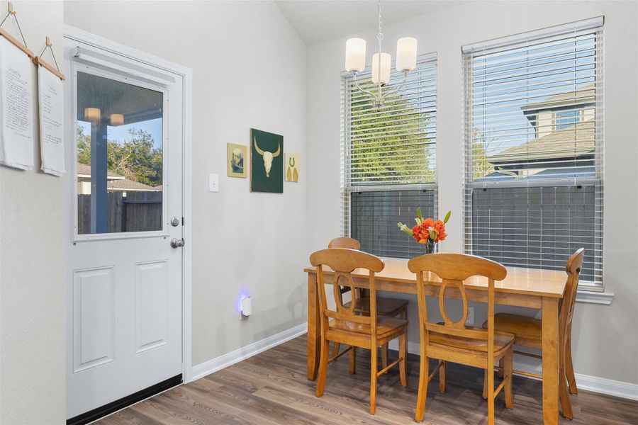 This bright dining area features large windows with blinds for natural light.