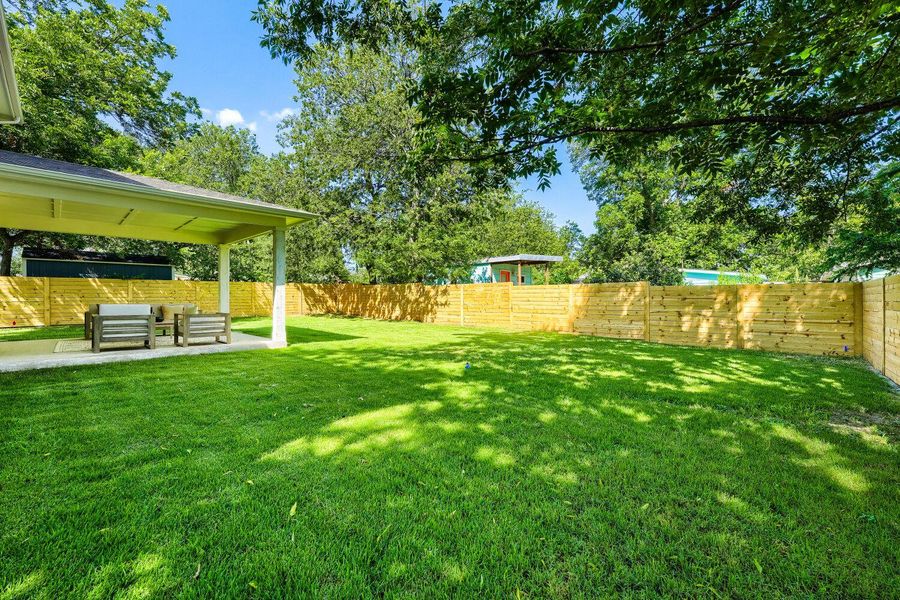A spacious, well-maintained lawn offers ample outdoor living with a covered patio for relaxation. A spacious, well-maintained lawn offers ample outdoor living with a covered patio for relaxation.
