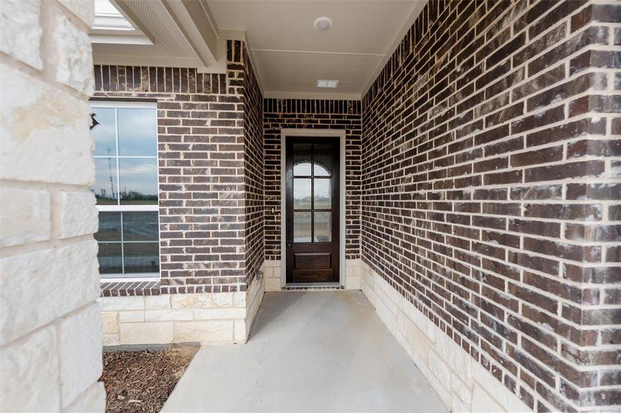 Doorway to property featuring brick siding Doorway to property featuring brick siding