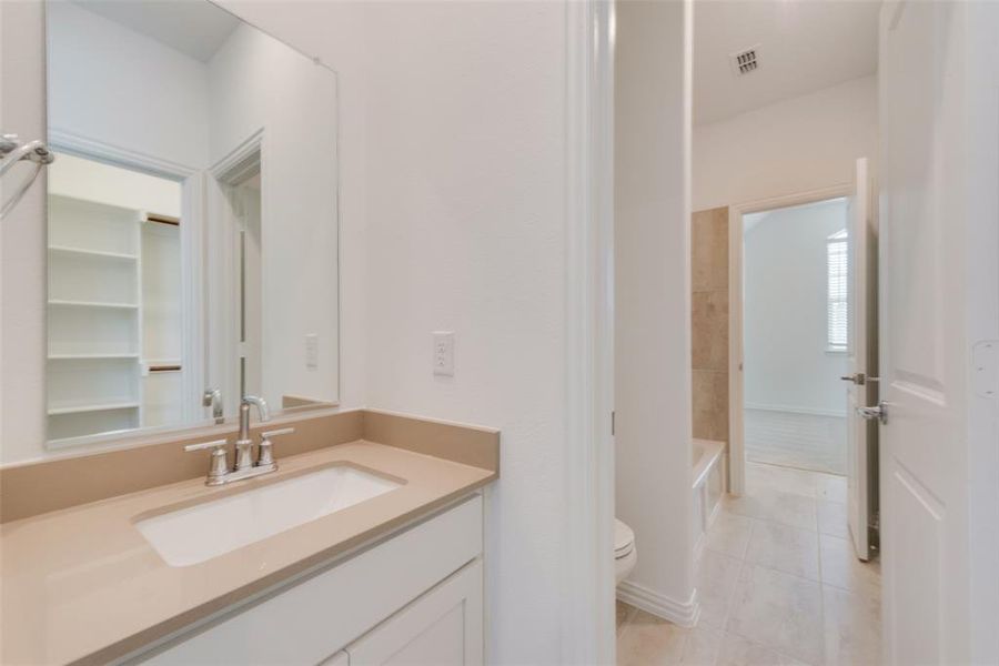 Full bathroom featuring vanity, tile patterned floors, washtub / shower combination, and toilet