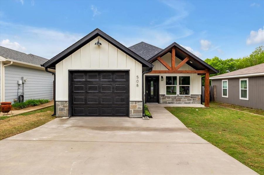 Modern farmhouse style home with a front lawn and a garage