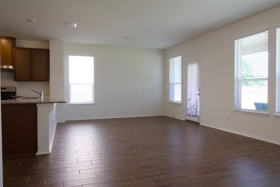 Flowing hardwood floors unite this open-concept kitchen and living area, ready for your personalized touch.