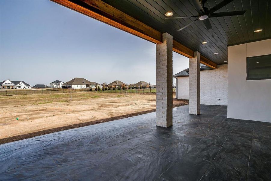 View of patio / terrace with fence, a residential view, and a ceiling fan