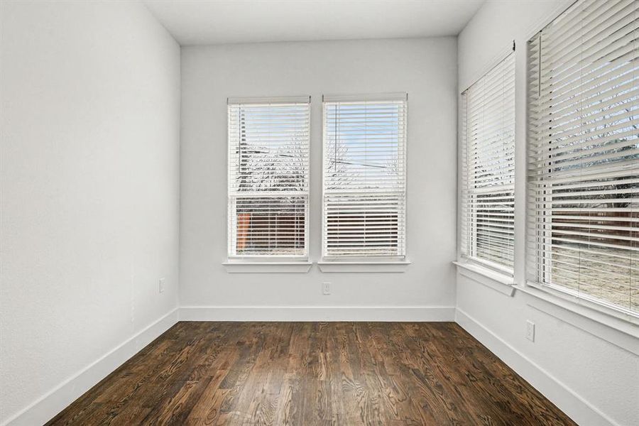 This secondary bedroom has two walls of dual windows for lots of light, a dual-door closet for storage, hardwood flooring and a lighted ceiling fan.