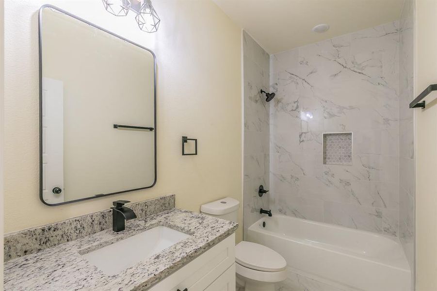 Full bathroom with vanity, toilet, and tiled shower / bath