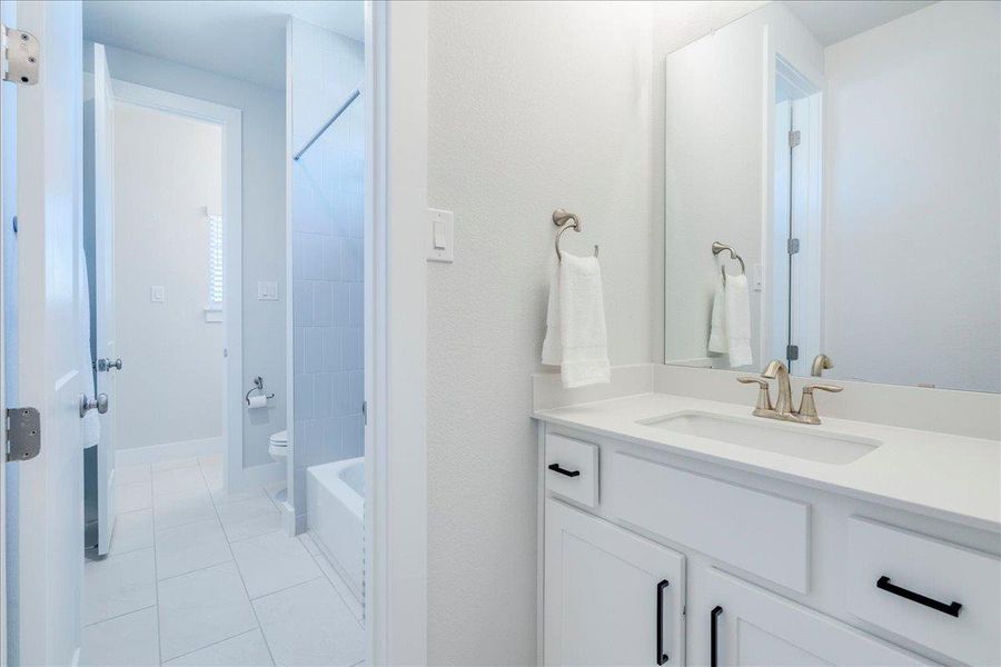 Bathroom with vanity, light tile patterned floors, and shower / bathtub combination Bathroom with vanity, light tile patterned floors, and shower / bathtub combination