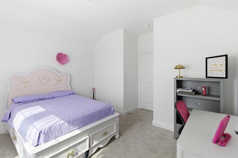 Carpeted room featuring crisp white walls and a vaulted ceiling