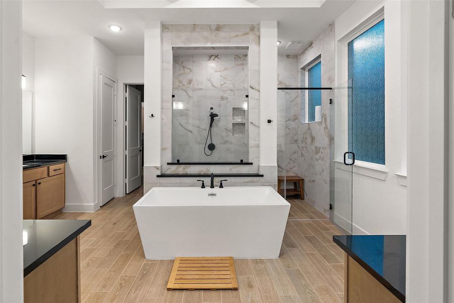 The first floor primary suite is at the back of the house offering added privacy and boasts dual vanities, soaking tub, oversized glass shower, and walk-in closet. The first floor primary suite is at the back of the house offering added privacy and boasts dual vanities, soaking tub, oversized glass shower, and walk-in closet.