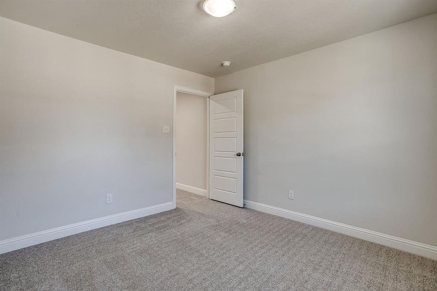 Unfurnished room featuring baseboards and light carpet